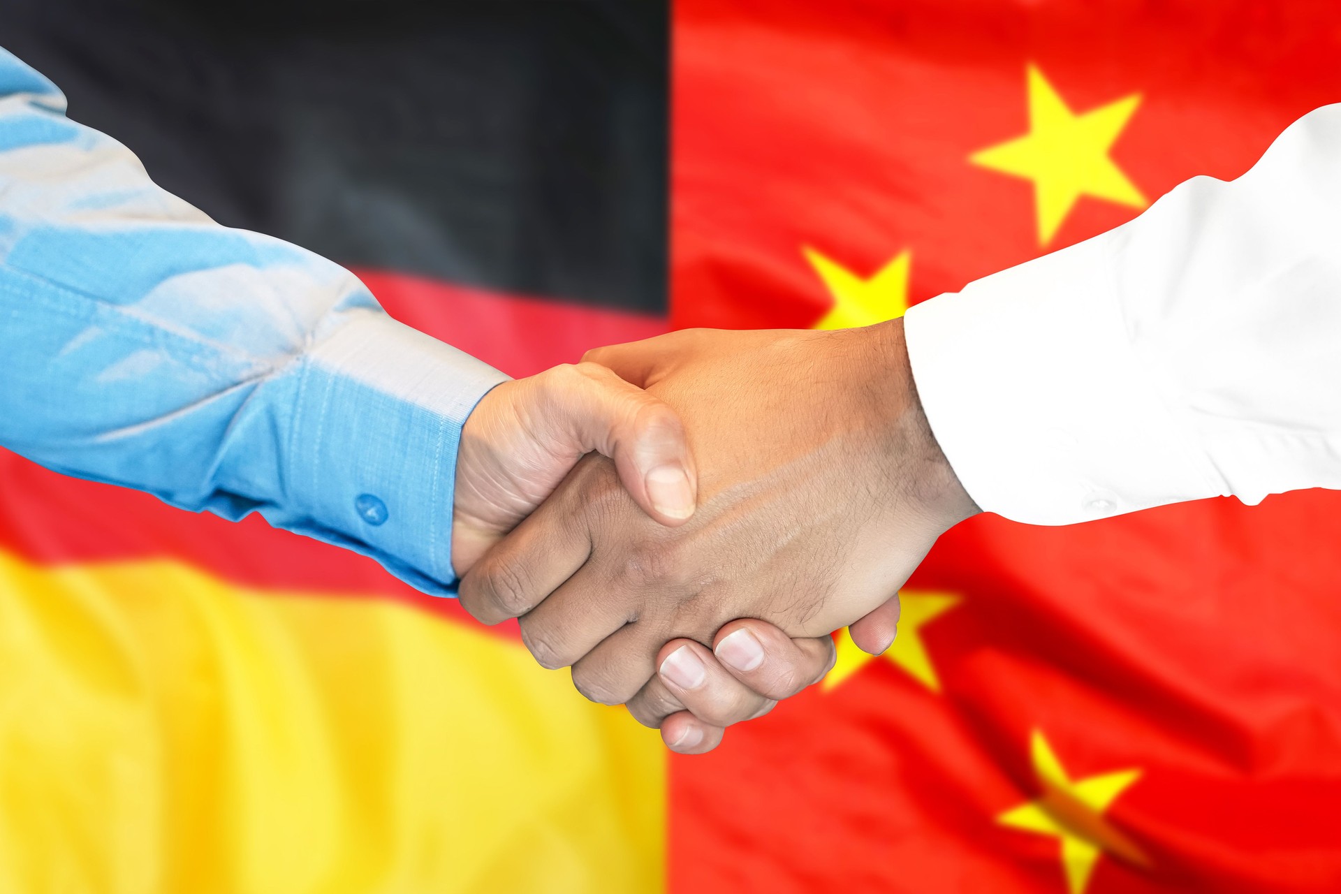 handshake on Germany and China flag background.